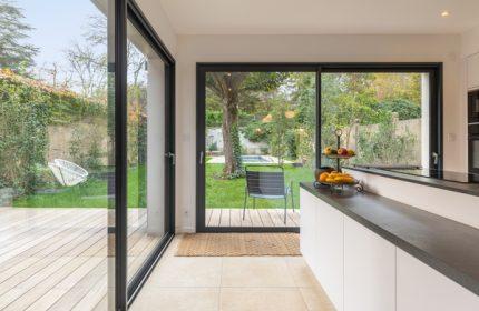 Cuisine moderne avancée sur le jardin. Maison de ville contemporaine en L de 147m² à Lyon